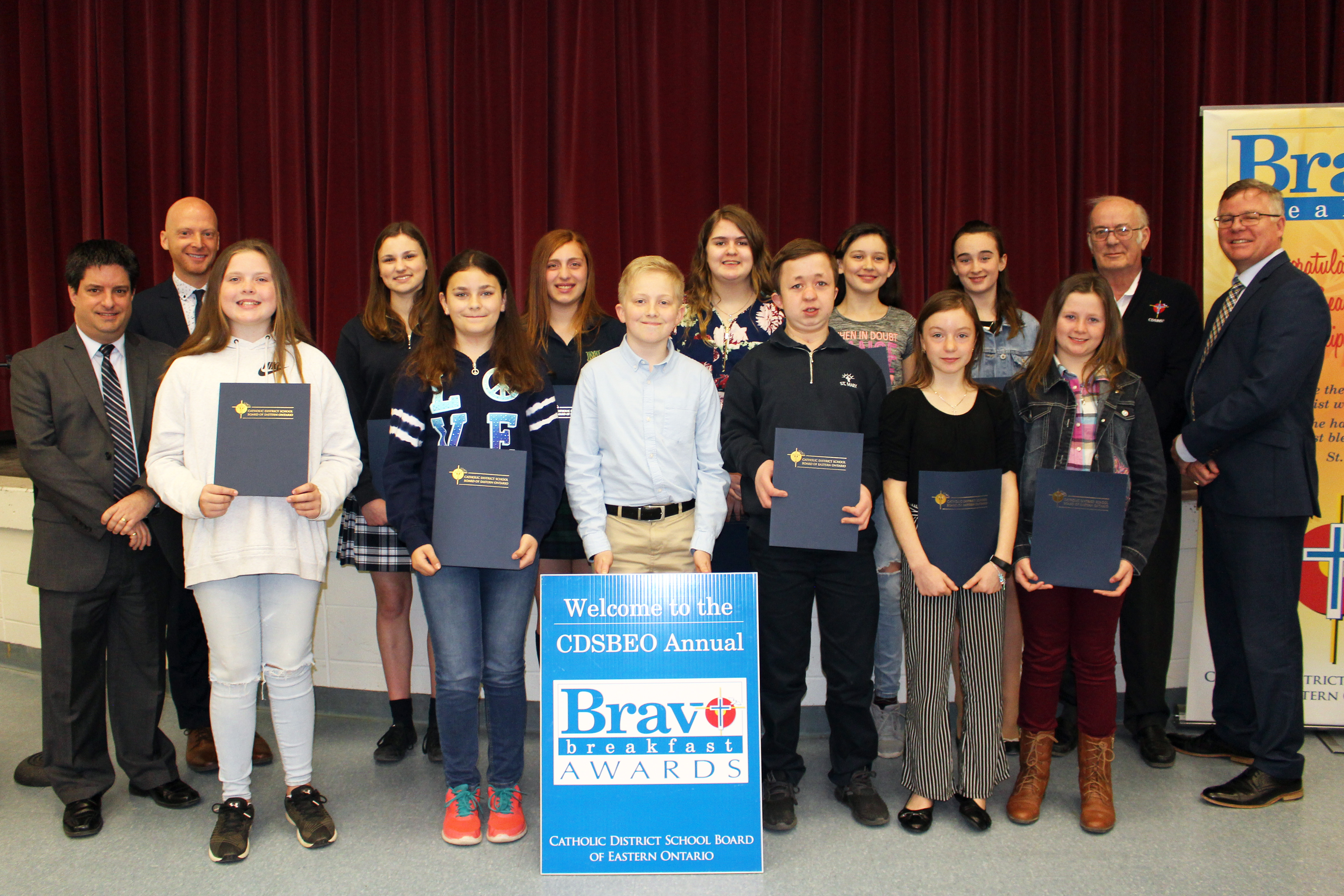 A group of students stand with their awards. 