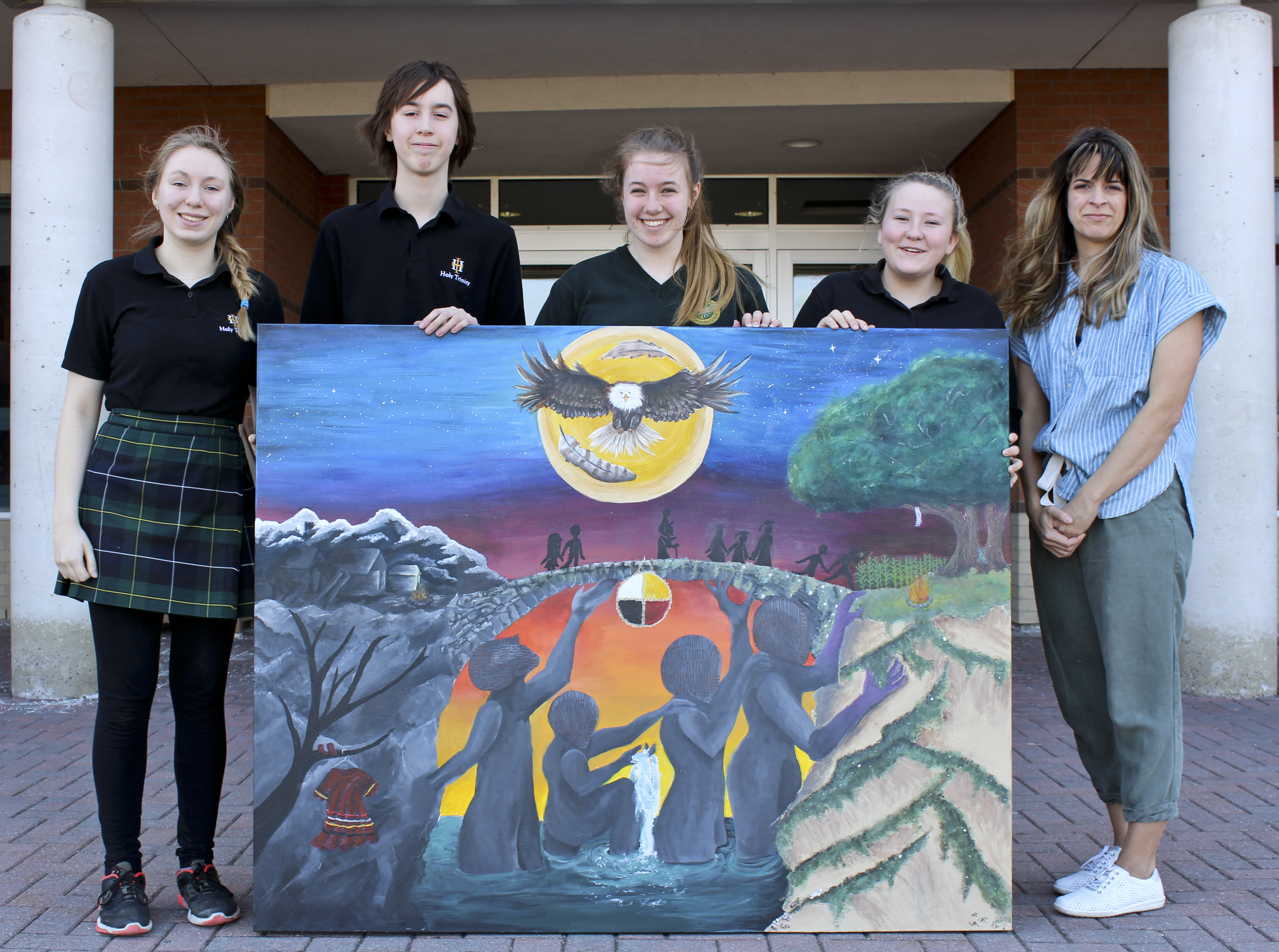 Students pose with a large painting.