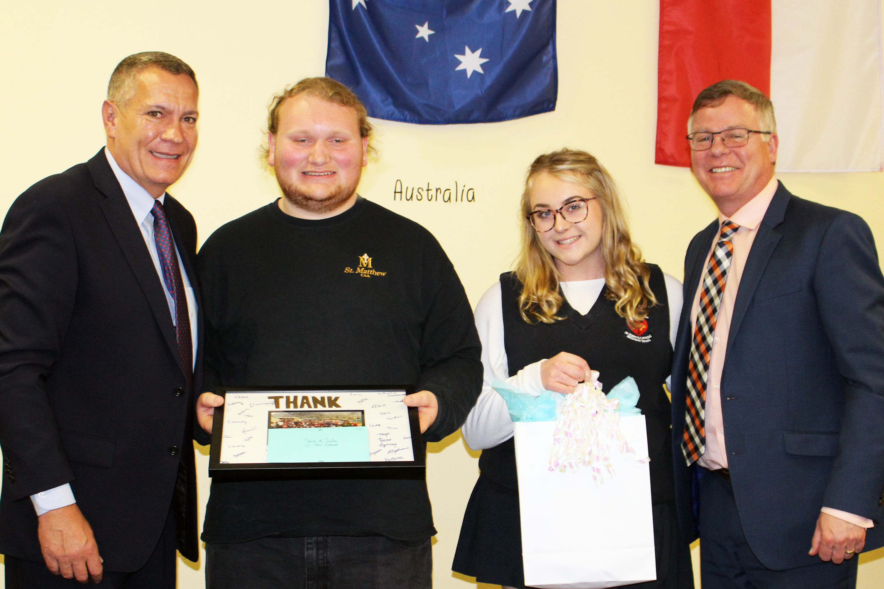Two students present a gift to CDSBEO Board Chair Todd Lalonde and Director John Cameron.