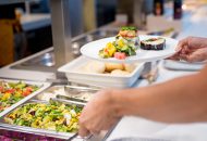 Cafeteria employee serving food.