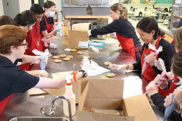 Students at St. Joseph Secondary School decorate smile cookies.