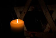 A candle lit in front of a star of David.