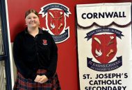 Student Isabelle Gillard stands with a St. Joseph's Catholic Secondary School banner.