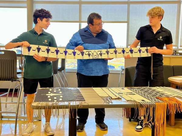 CDSBEO Indigenous Cultural Advisor Allen Smoke holding up a Wampum Belt with two students.