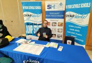 CDSBEO Indigenous Skilled Trades Fair table with teacher and banners in the background.